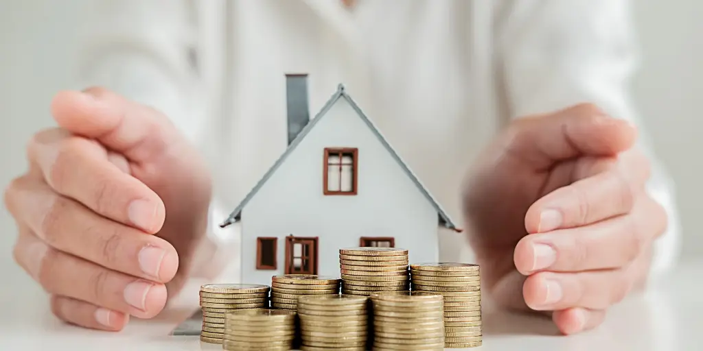 hands holding a model house and stacks of coins saving money on a Tucson move